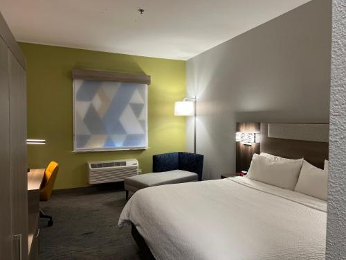 um quarto de hotel com uma cama e uma cadeira em Holiday Inn Express Hotel & Suites Woodward Hwy 270, an IHG Hotel em Woodward