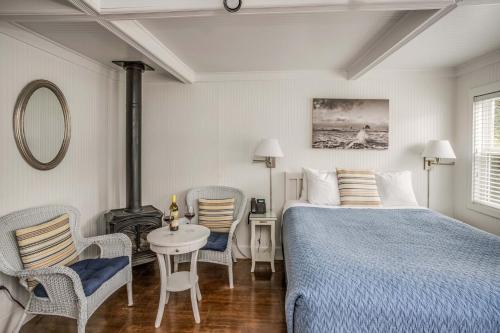 a bedroom with a bed and a table and chairs at Cannon Beach Hotel Collection in Cannon Beach