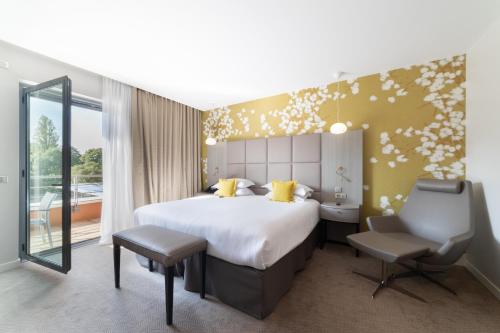 a bedroom with a bed and a desk and a chair at Crowne Plaza Lyon - Cité Internationale in Lyon