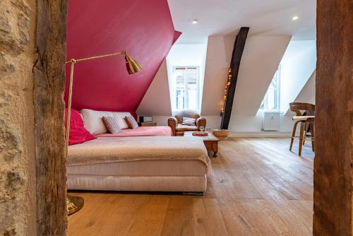 sala de estar con sofá y pared de color rosa en Pasteur Numéro 5, en Dijon