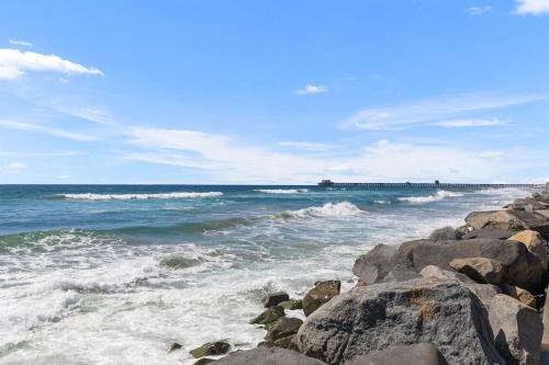a beach with rocks and the ocean with waves at Oceanfront, Private Patio, BBQ, On The Strand in Oceanside
