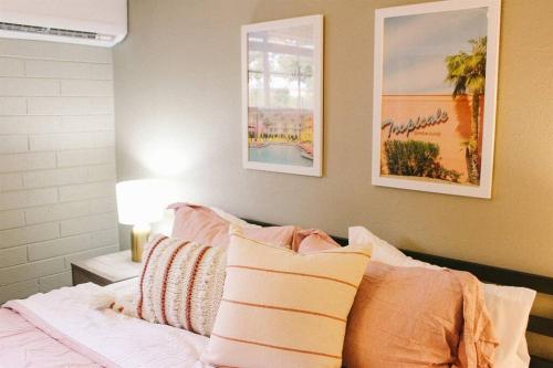 a bedroom with a bed with two pictures on the wall at Remodeled Modern Ground Level Apt Blocks to Dwntn - B in Tempe