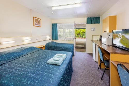 a hotel room with a bed and a desk at Roma Motel in Roma