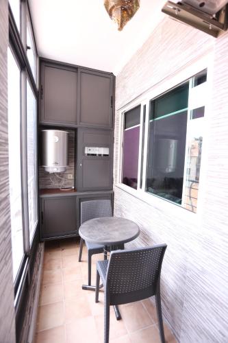 a small patio with a table and two chairs at APPARTEMENT AMIRA iFRANE in Ifrane