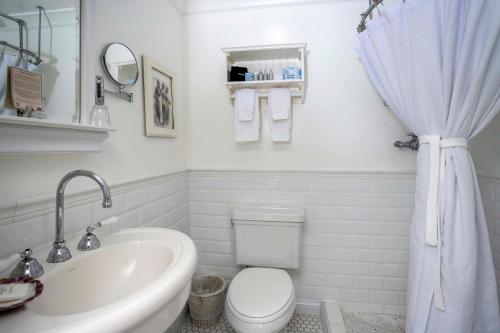 a white bathroom with a toilet and a sink at Cannon Beach Hotel Collection in Cannon Beach