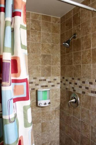 a shower with a colorful shower curtain in a bathroom at Adorable Ground Level Boho Studio Blocks From Dwntn-C in Tempe