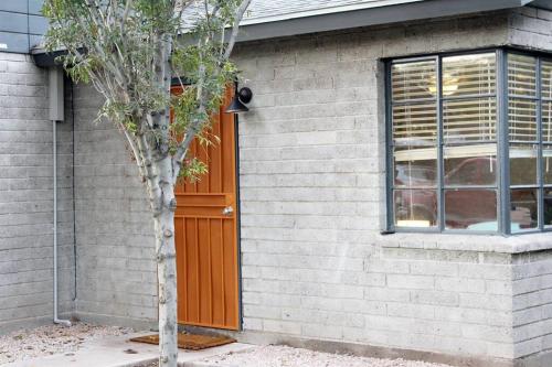 a tree in front of a house with a door at Adorable Ground Level Boho Studio Blocks From Dwntn-C in Tempe