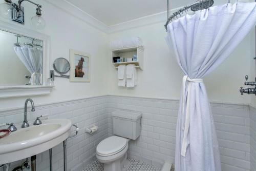 a white bathroom with a toilet and a sink at Cannon Beach Hotel Collection in Cannon Beach