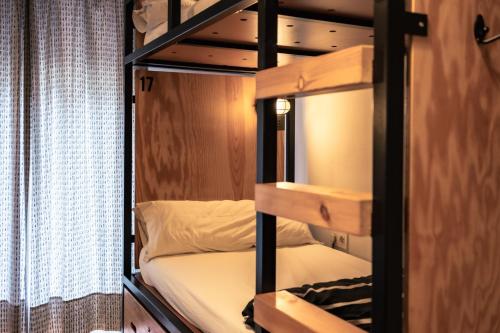 a bunk bed in a small room with a bunk bedutenewayangering at Surfing Etxea - Surf Hostel in San Sebastián