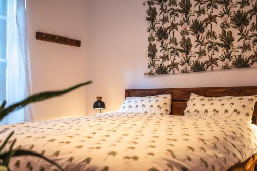 1 dormitorio con 1 cama con colcha de flores en Surfing Etxea - Surf Hostel, en San Sebastián