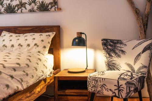 ein Schlafzimmer mit einem Bett, einem Stuhl und einer Lampe in der Unterkunft Surfing Etxea - Surf Hostel in San Sebastián