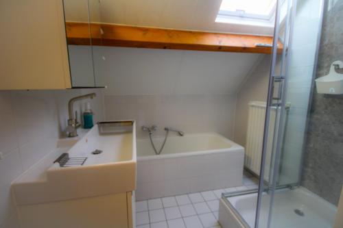 a bathroom with a tub and a sink and a shower at Huisje 11 Wemeldinge in Wemeldinge