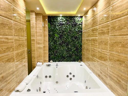 a bath tub in a bathroom with a green wall at Apartmani SLEEP&JOY in Zlatibor