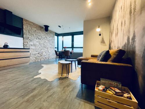 a living room with a couch and a table at Boutique apartment Heidi with mountain view in Loučná pod Klínovcem