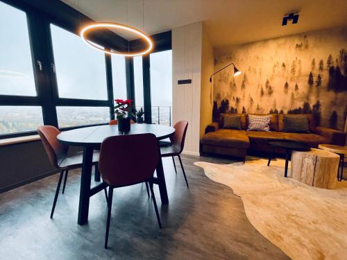 a living room with a table and chairs and a couch at Boutique apartment Heidi with mountain view in Loučná pod Klínovcem