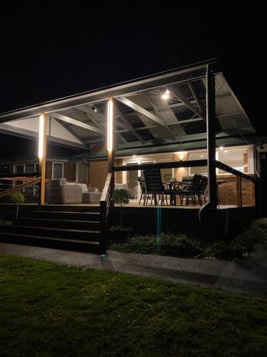 a covered deck with a table and chairs at night at The Residence - Yarra Valley in Wandin North