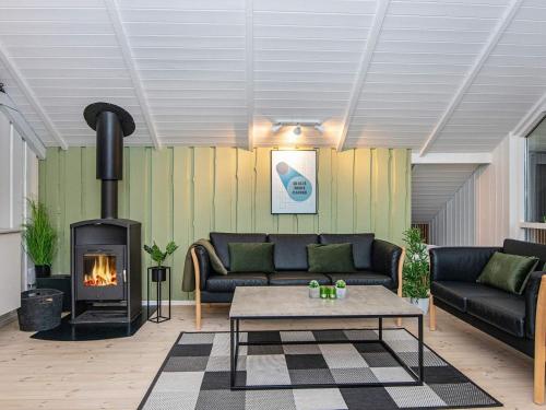 a living room with a couch and a fireplace at 6 person holiday home in Hovborg in Hovborg