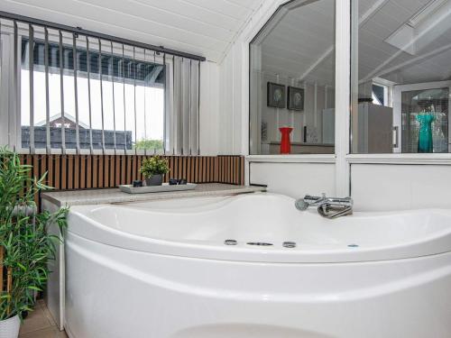 bañera blanca en una habitación con ventana grande en 6 person holiday home in Hovborg, en Hovborg