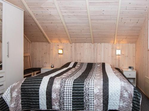 een slaapkamer met een bed in een kamer met houten wanden bij Holiday home Ansager XLIII in Ansager