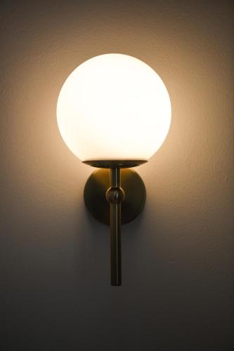 a lamp with a white light on a wall at Tamworth Country Escape with a beautiful swimming pool! in Loomberah