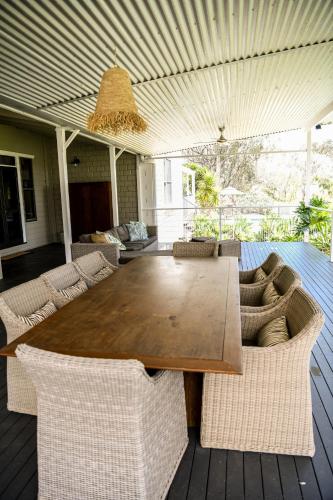 a wooden table and chairs on a patio at Tamworth Country Escape with a beautiful swimming pool! in Loomberah