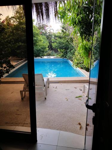 a view of a swimming pool through a sliding glass door at Belle villa in Poponguine