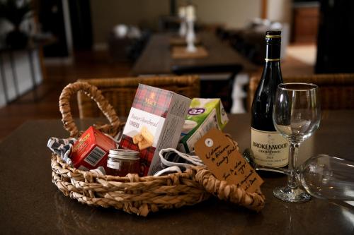 a basket of food and a bottle of wine on a table at Tamworth Country Escape with a beautiful swimming pool! in Loomberah