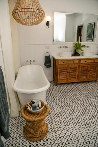a bathroom with a tub and a toilet and a sink at Tamworth Country Escape with a beautiful swimming pool! in Loomberah