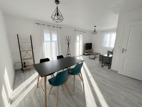 uma sala de estar com uma mesa preta e cadeiras em 178A - T3 Tout Confort du Gond - 70 m2 em Le Gond-Pontouvre