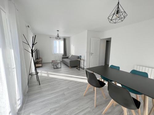 178A - T3 Tout Confort du Gond - 70 m2 في Le Gond-Pontouvre: غرفة طعام وغرفة معيشة مع طاولة وكراسي