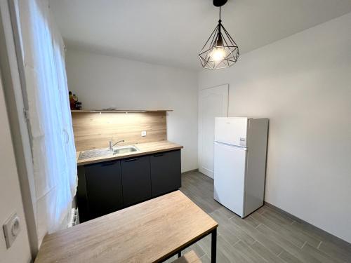 a kitchen with a sink and a refrigerator at 178A - T3 Tout Confort du Gond - 70 m2 in Le Gond-Pontouvre