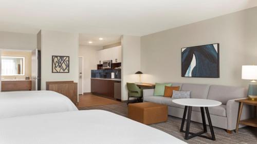 Staybridge Suites - Lexington S Medical Ctr Area, an IHG Hotel في ليكسينغتون: غرفة فندقية بسريرين واريكة