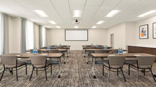 a conference room with tables and chairs and a whiteboard at Staybridge Suites - Lexington S Medical Ctr Area by IHG in Lexington