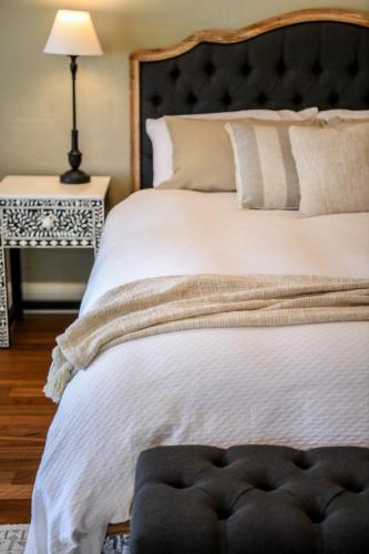 a bedroom with a large white bed with a black headboard at Tamworth Country Escape with a beautiful swimming pool! in Loomberah