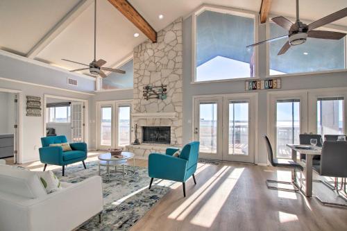 a living room with a stone fireplace and blue chairs at Sunny Lakefront Escape with Private Beach and Deck in Burnet
