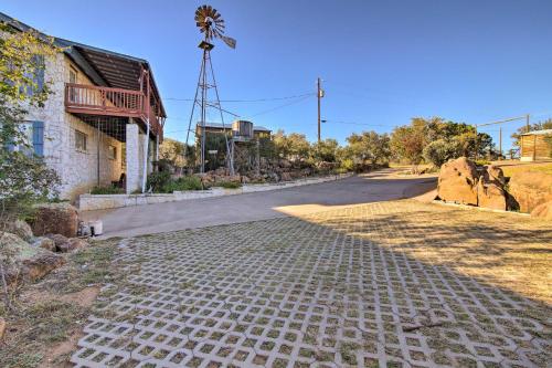 an empty street with a windmill in the distance at Sunny Lakefront Escape with Private Beach and Deck in Burnet