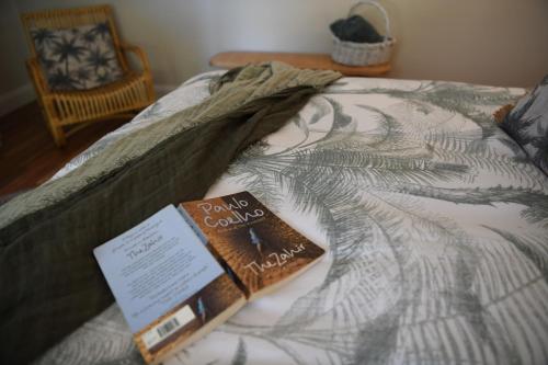 a book sitting on top of a bed at Tamworth Country Escape with a beautiful swimming pool! in Loomberah