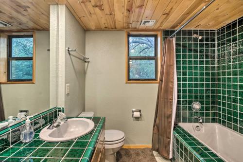 La salle de bains est pourvue d'un lavabo, d'une baignoire et de toilettes. dans l'établissement Spacious Pine Mountain Club Cabin with Fire Pit, à Pine Mountain Club