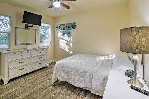 a bedroom with a bed and a dresser with a television at Bright Tallahassee Home with Deck, 3 Mi to FSU! in Tallahassee