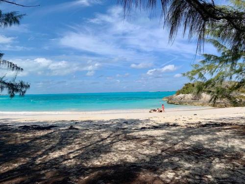 a beach with people sitting on the sand and the ocean at Sunset Cove in Forbes Hill