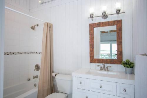 uma casa de banho com um WC, um lavatório e um espelho. em Sunset Cove em Forbes Hill
