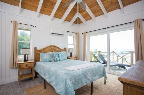 a bedroom with a bed with a blue comforter at Sunset Cove in Forbes Hill