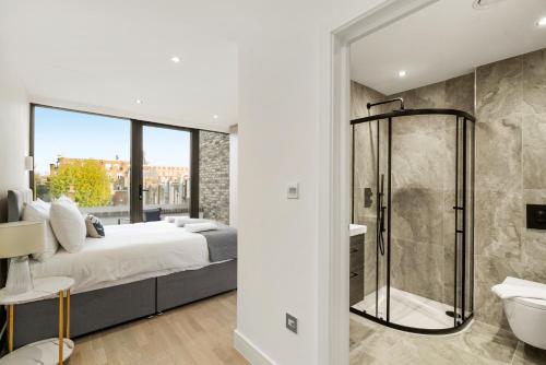 ein Schlafzimmer mit einem Bett und einer Dusche sowie ein Badezimmer in der Unterkunft Executive 1 & 2 Bed Apartments in heart of London FREE WIFI by City Stay Aparts London in London