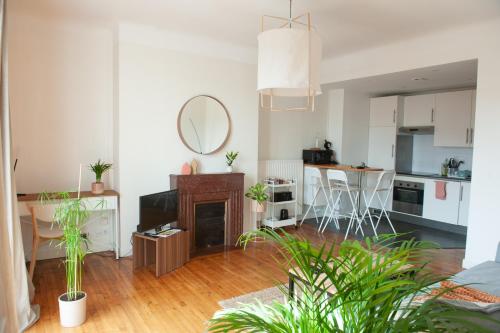a living room with a fireplace and a kitchen at Appartement spacieux avec balcon et parking in Brest