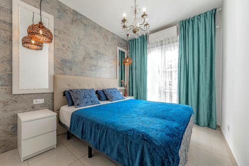 um quarto com uma cama azul e cortinas verdes em Beautiful deluxe apartment Sun and Sea em Adeje