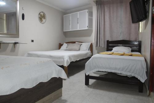 um quarto com duas camas e uma tv nele em HOTEL PRIMAVERA RIOHACHA em Ríohacha