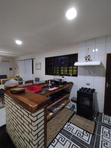 een keuken met een aanrecht en een woonkamer bij Casa do adalto in Ilhabela