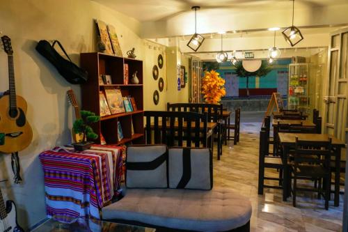 een restaurant met een gitaar en een tafel en stoelen bij Hotel Los Andes Boutique in Huaraz