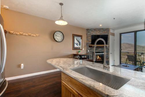 a kitchen with a large sink and a fireplace at The Lodge at Stillwater #2012 in Heber City