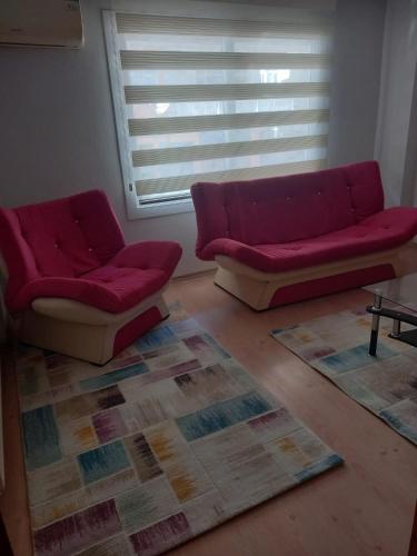 a living room with a red couch and two chairs at EKONOMİ ÜNİVERSİTESİNE 5 Dk. 2+1 EŞYALI DAİRE in Balcova